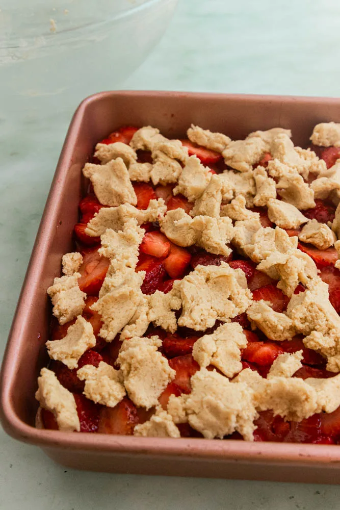 Crumble the remaining 1/3 of the cookie dough over the top of the strawberries.